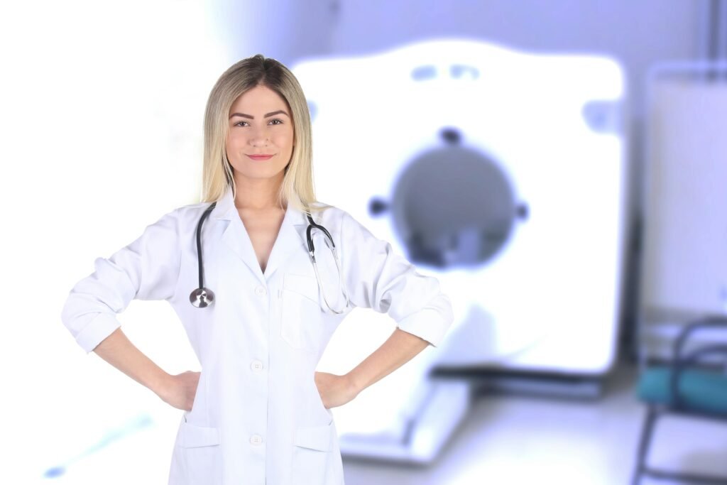 Young female doctor standing confidently with medical equipment in the background.